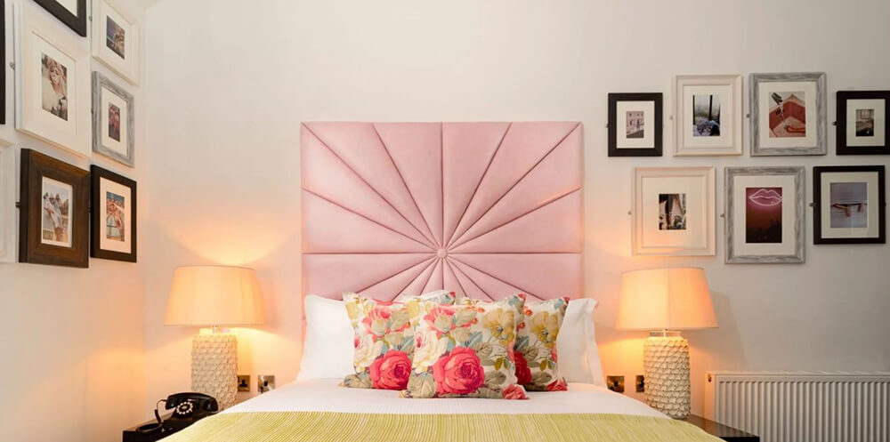 Black Ivy, Edinburgh - bedroom pink headboard and lots of small framed artworks - Supply of mirrors and pictures